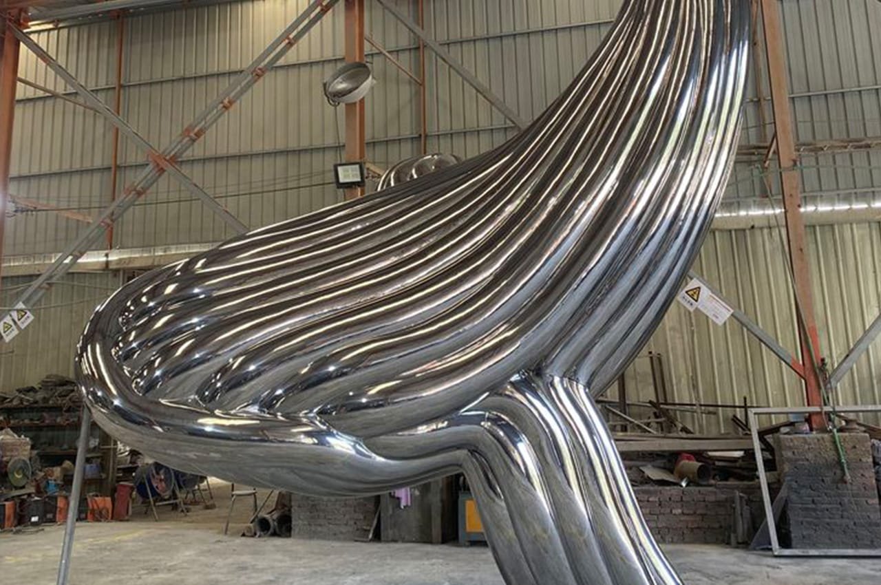 Polished stainless steel sculpture in a fabrication workshop