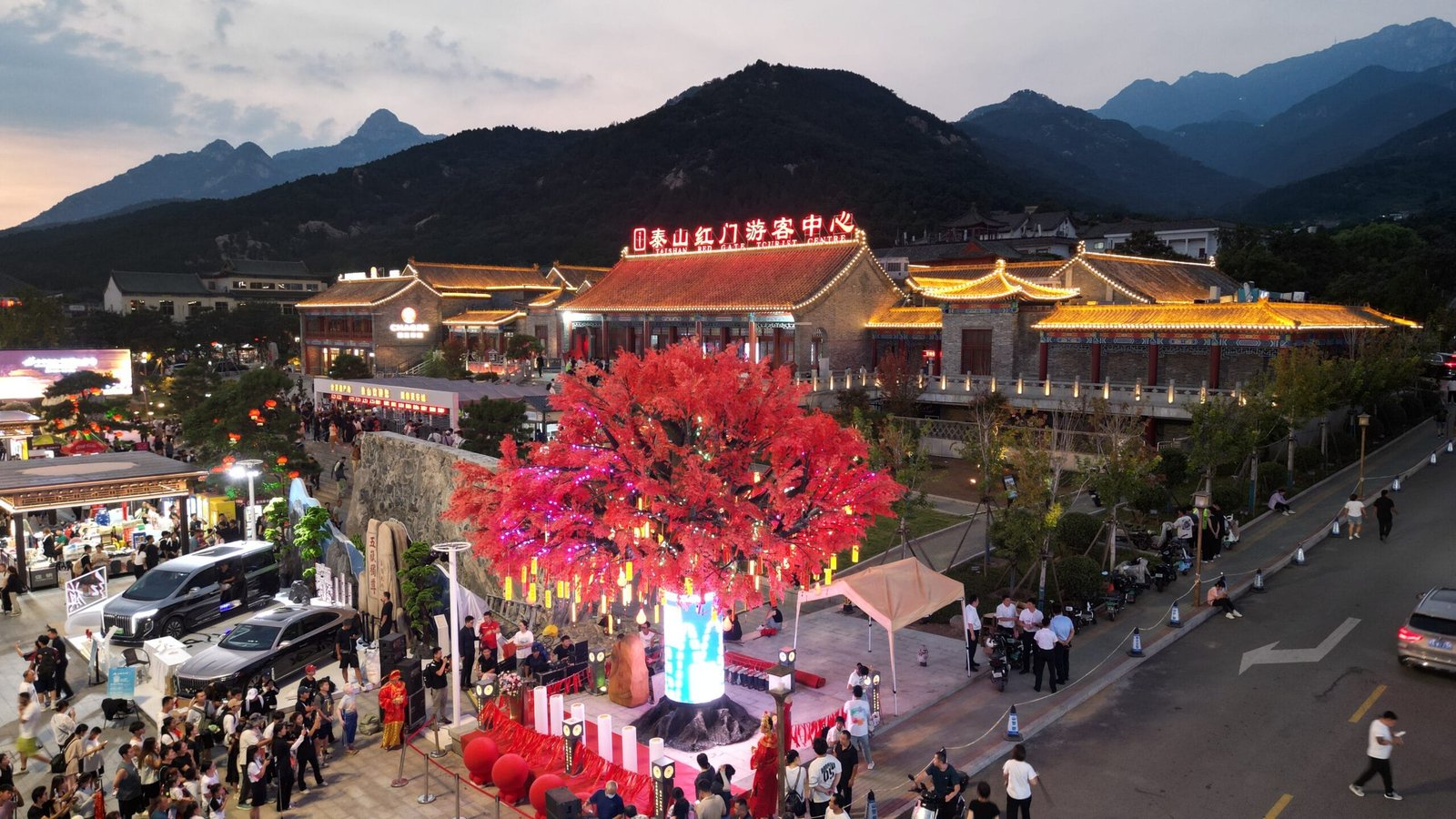 Illuminated tree-style landmark installation in a cultural tourism plaza at dusk