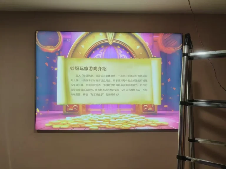 A wall-mounted screen displays the introduction to the “钞级玩家” interactive game; a ladder is visible beside it.
